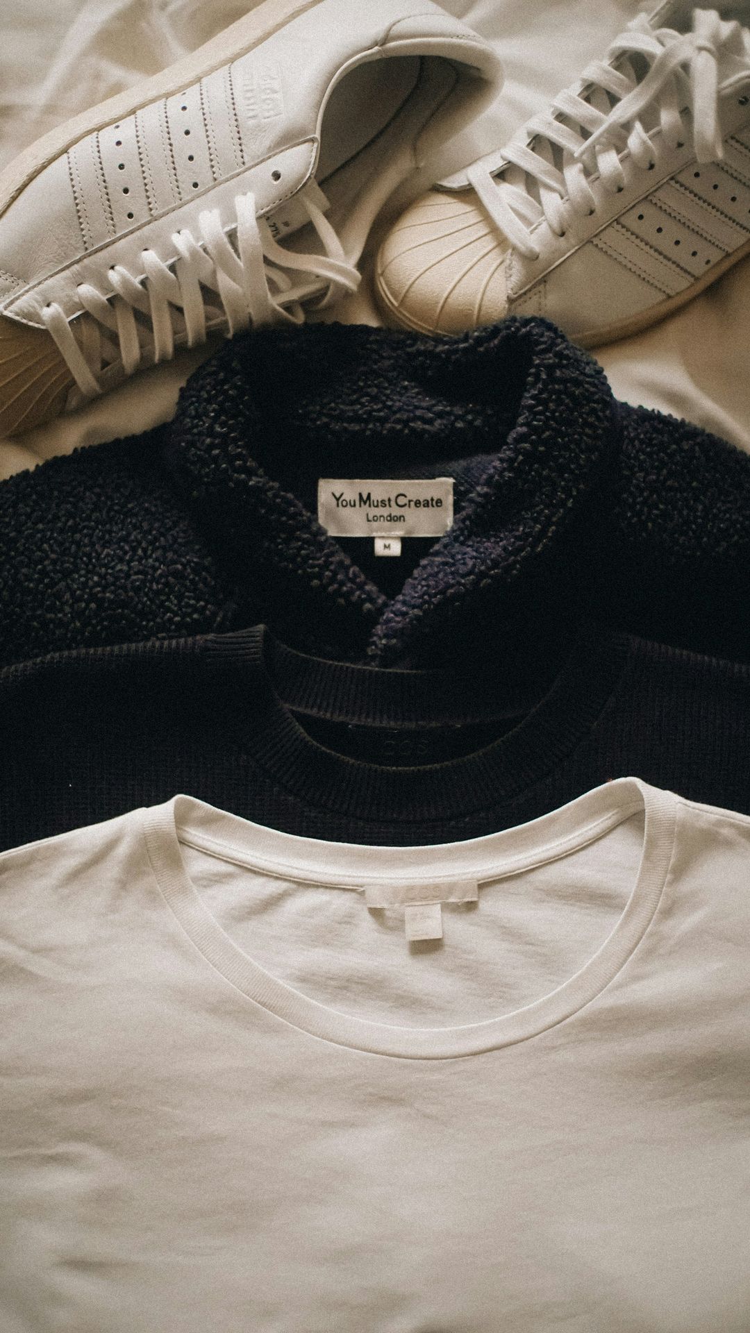 a pair of sneakers and a t - shirt on a bed